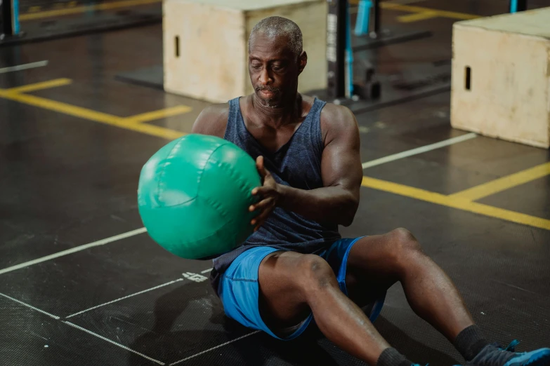 a man sitting on the floor with a ball