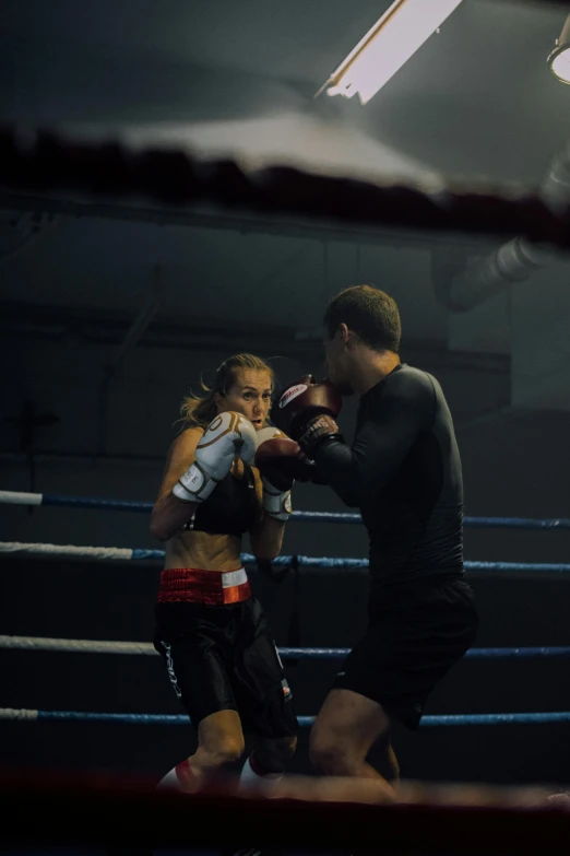 young man in boxing ring talking to a female boxer