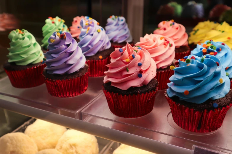 colorful frosted cupcakes lined up in a row