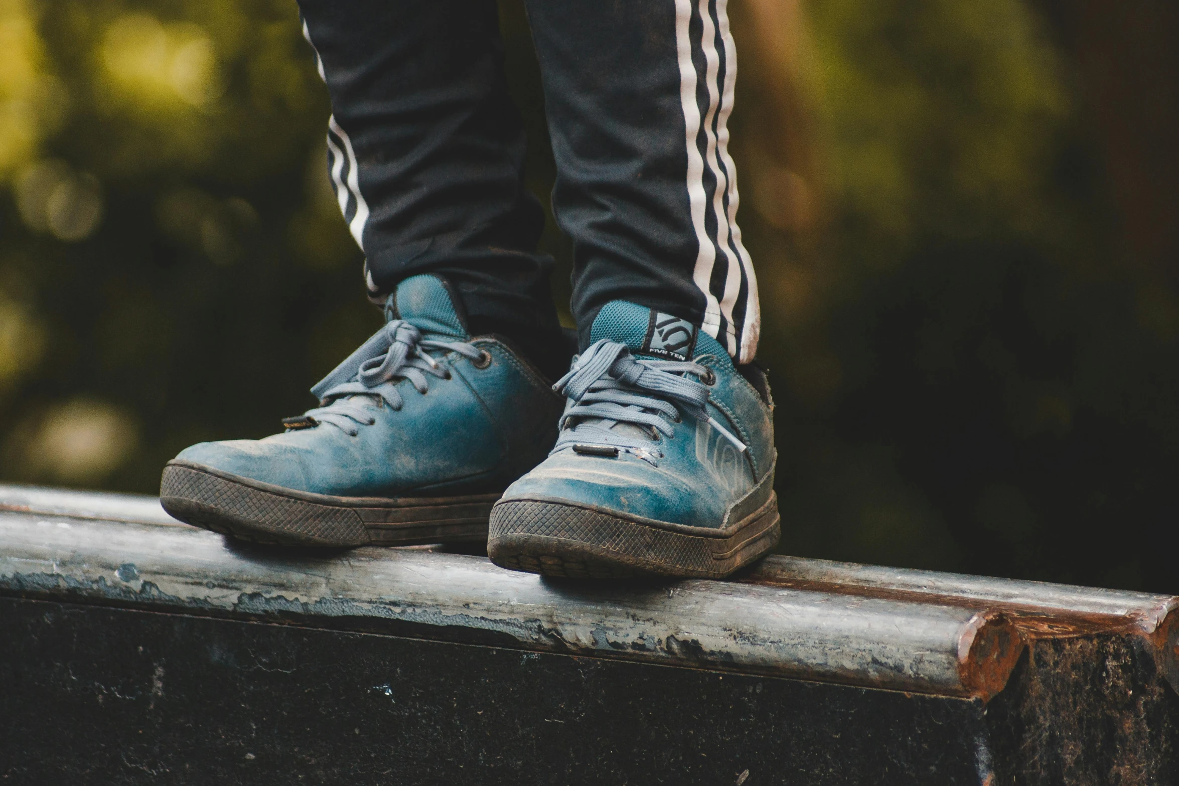 the man's shoes are on the edge of the railing