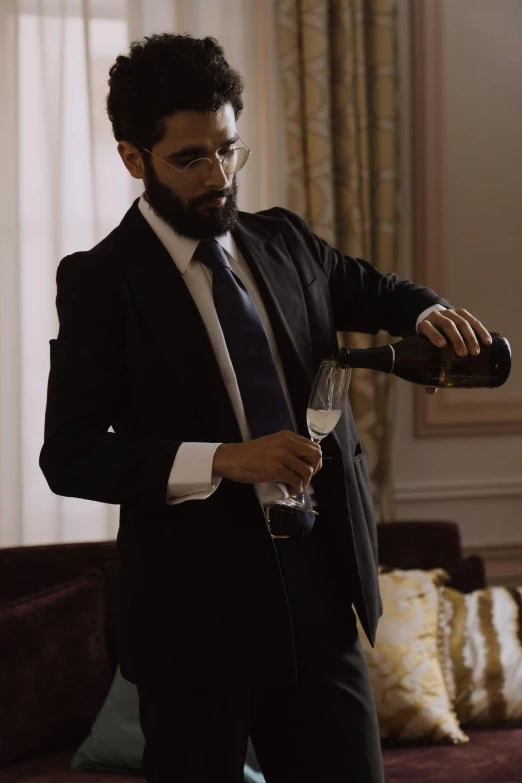 man pouring wine into wine glass wearing suit and tie