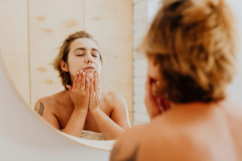 the reflection of a young woman looking in the mirror