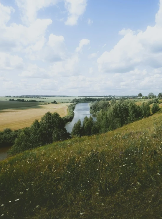 the green countryside is next to the river