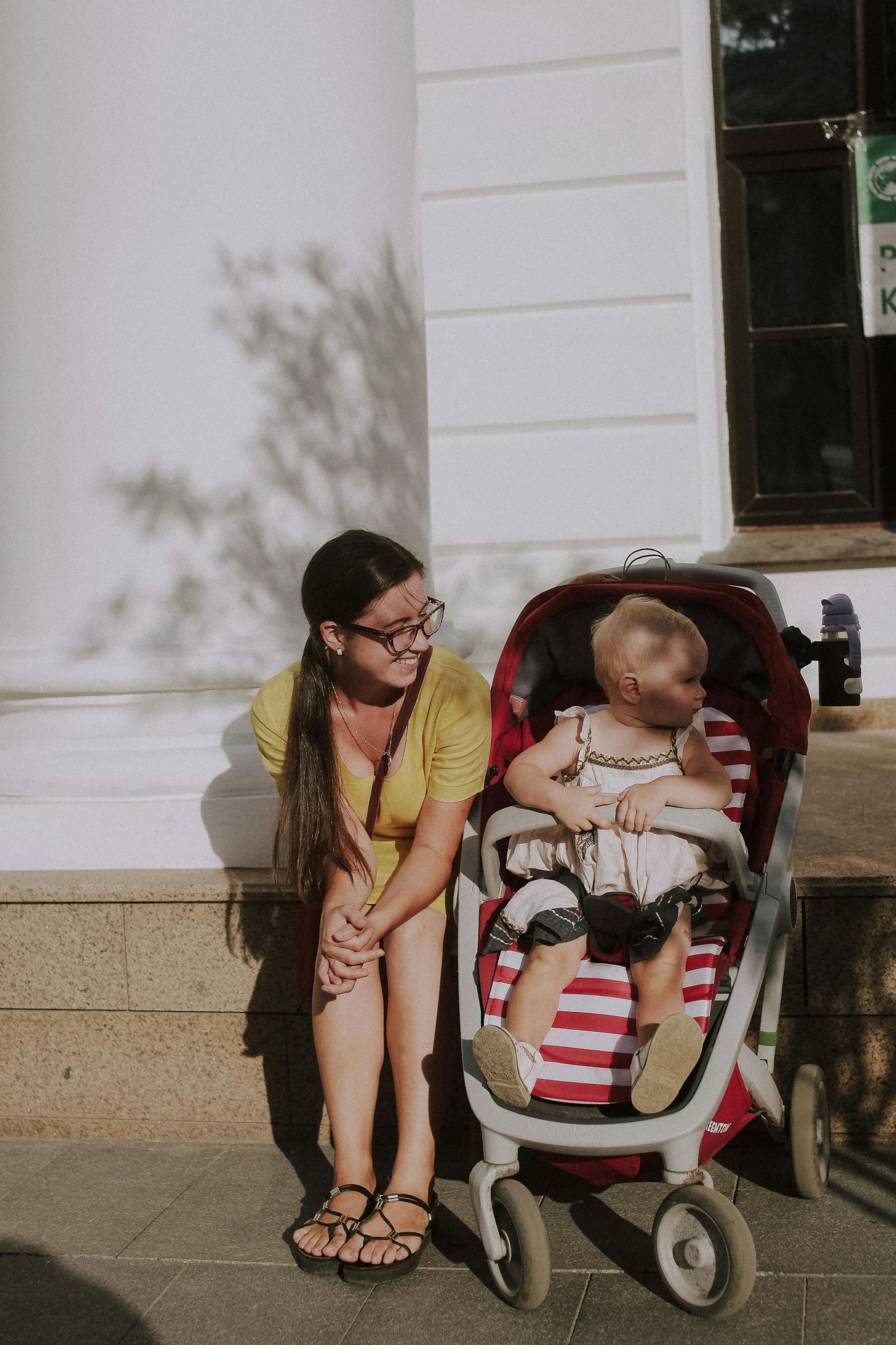 the woman is sitting with her baby in a stroller