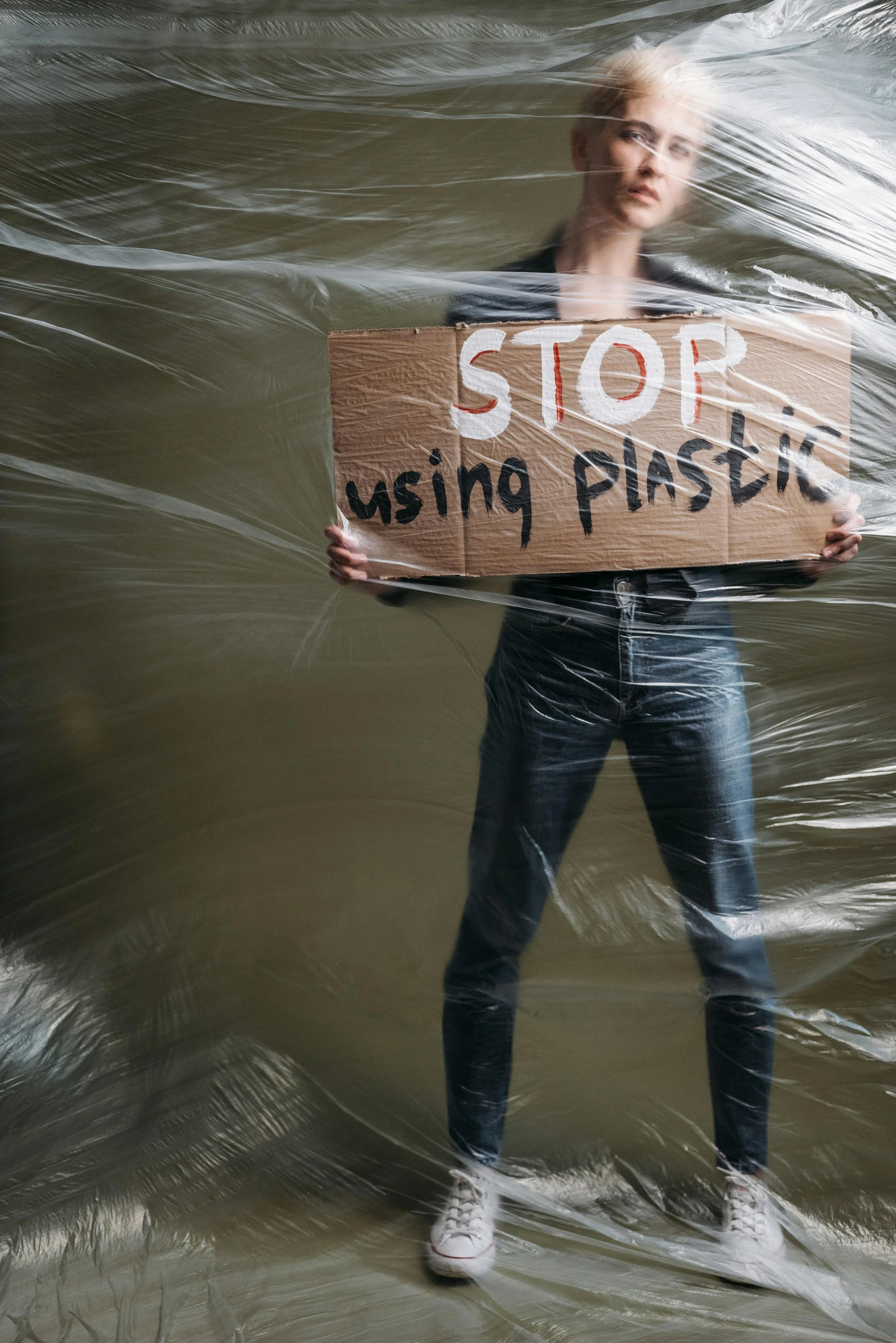 a man in black pants standing in a pool holding a sign