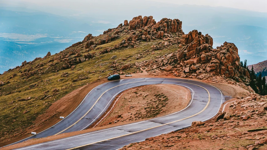 a winding mountain road leads through the rocky landscape