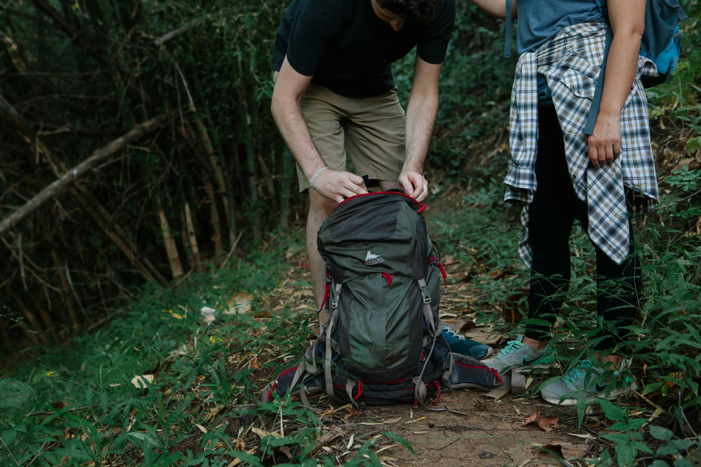 two young people are standing in the woods together