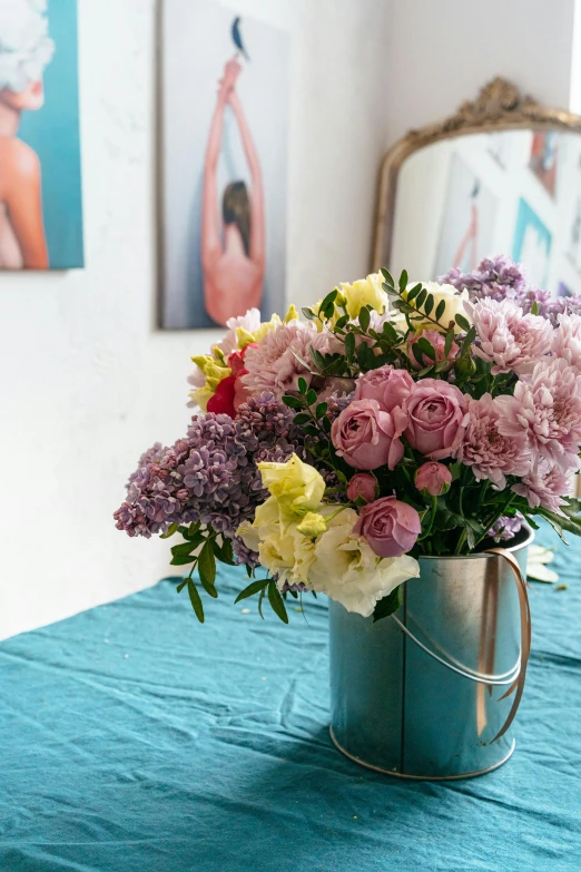 a metal mug filled with some pretty flowers