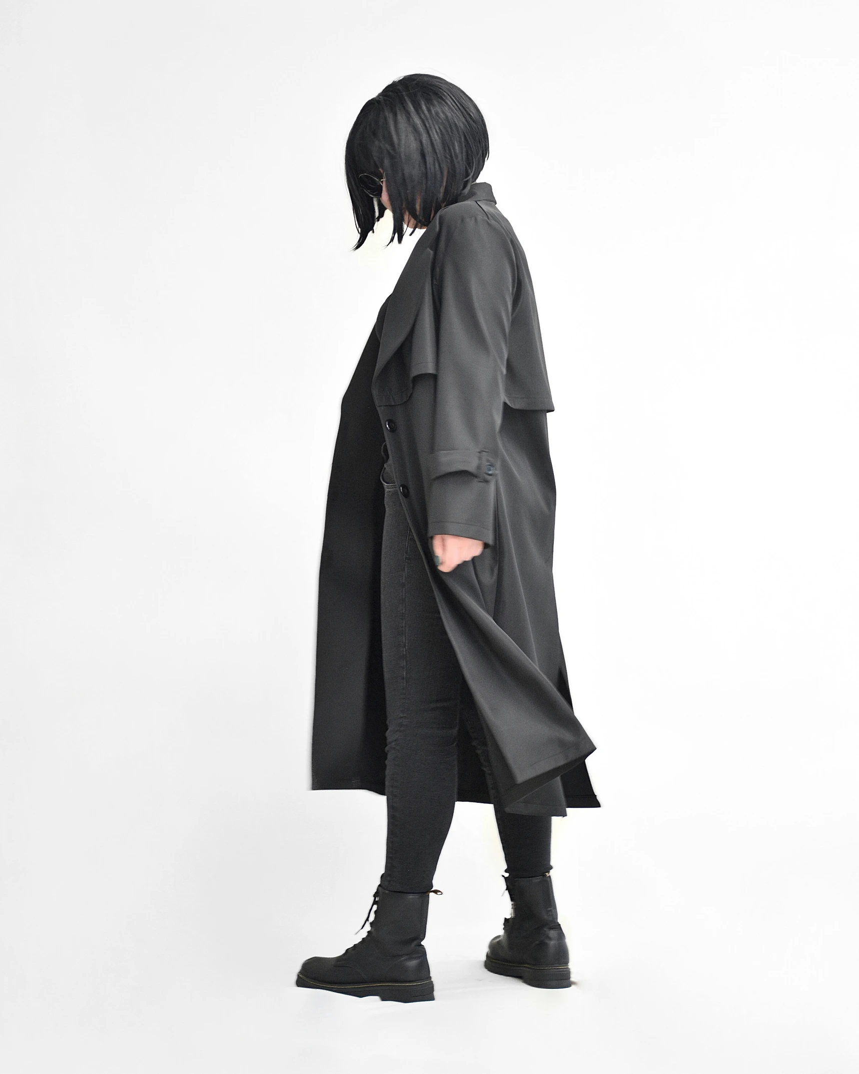 the back of a woman in black clothes wearing a coat