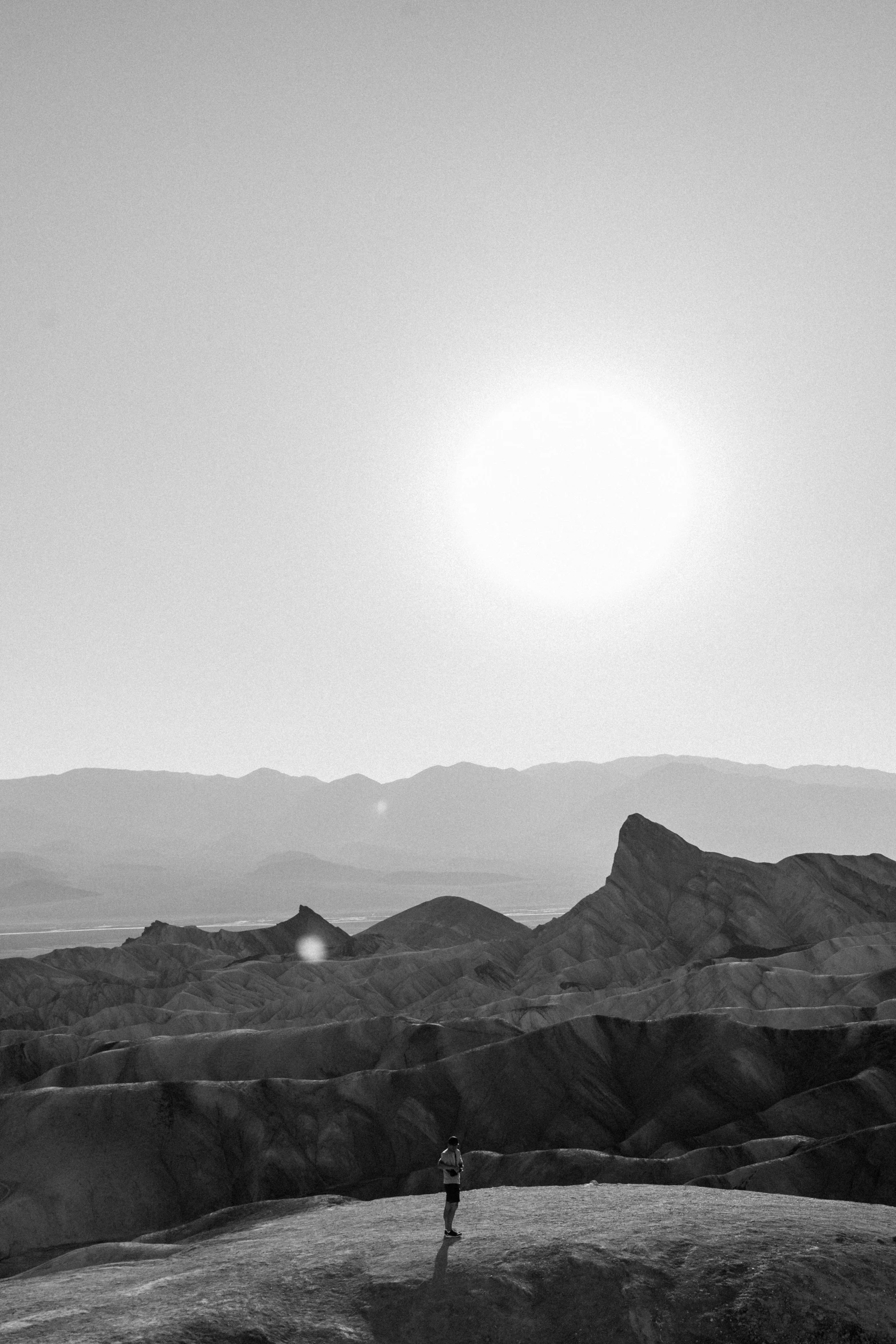 a person standing in a field on a hill with mountains