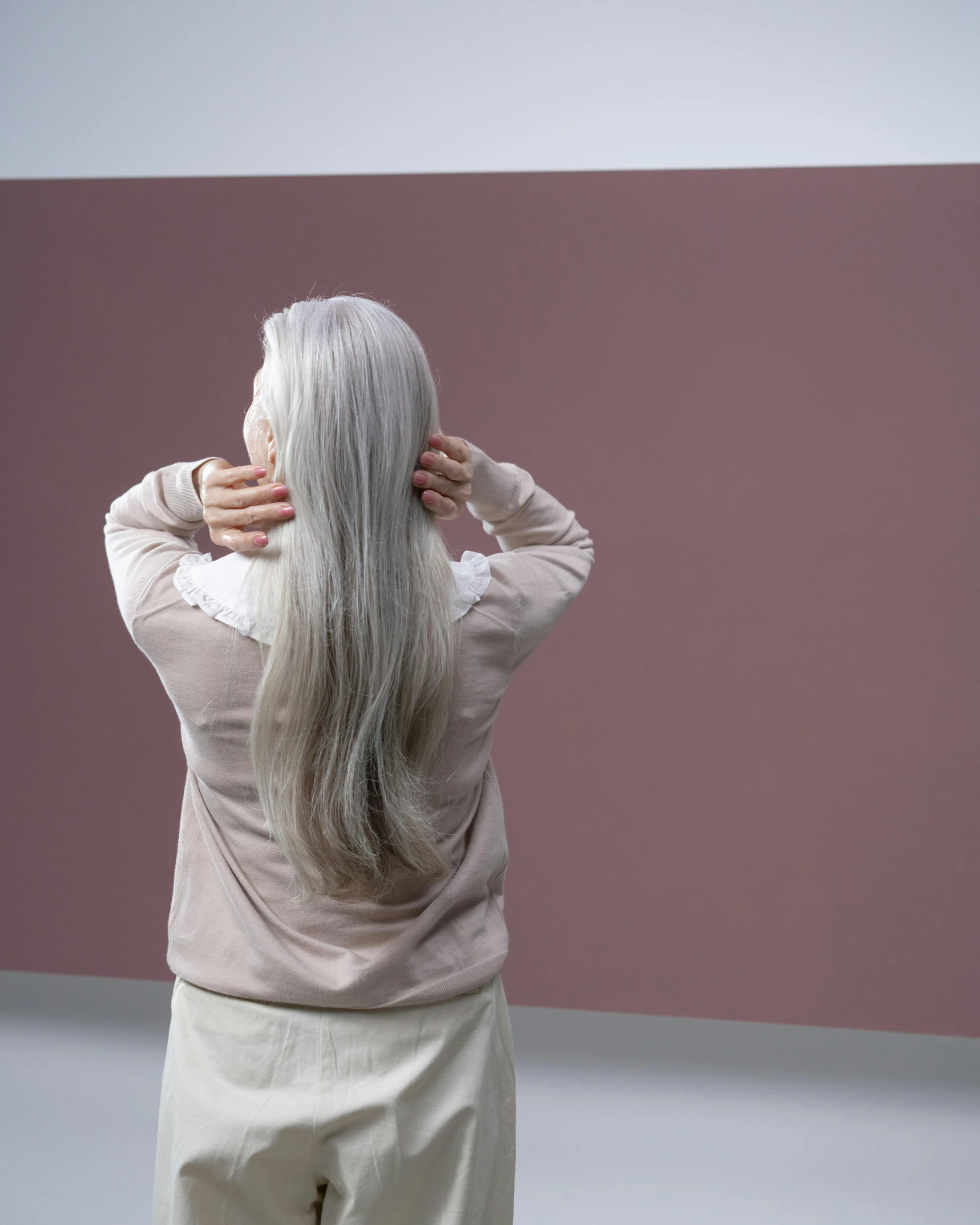 a woman with long hair looking at soing behind her head