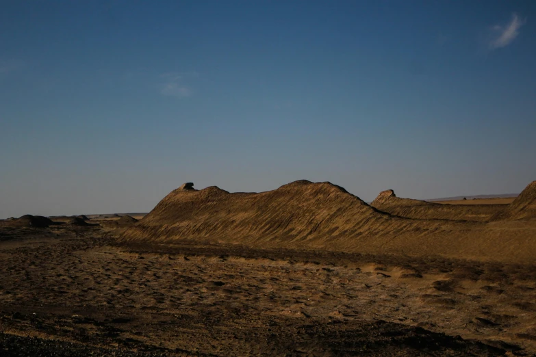 some hills with rocks in them and a cloudless sky