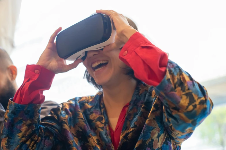 a man wearing glasses covering his eyes is next to a woman who has a cell phone in her hand