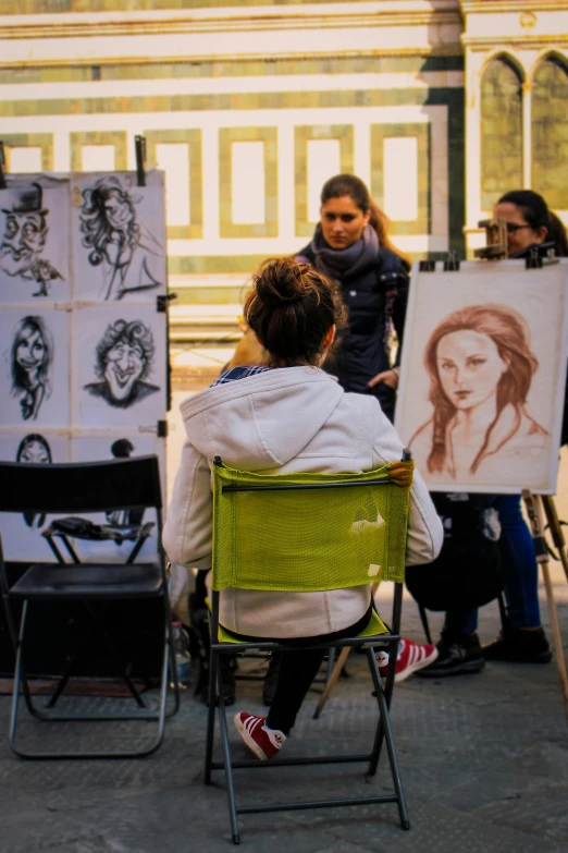 a woman is sitting in front of easels while she uses an art drawing technique