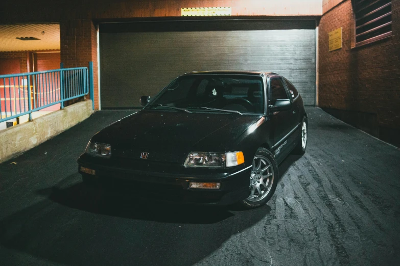 a black car parked in front of a garage