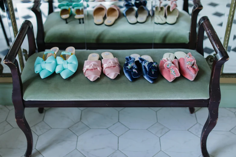 six pairs of little girl's shoes on a bench