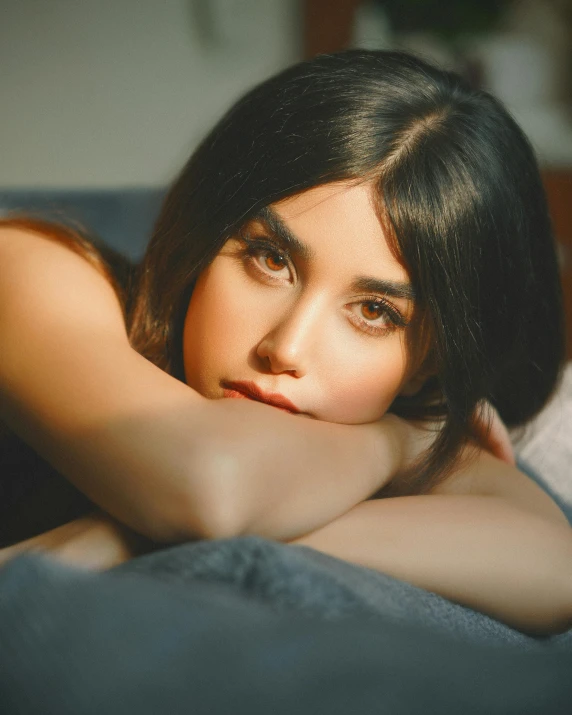 a woman lying on top of a blue couch