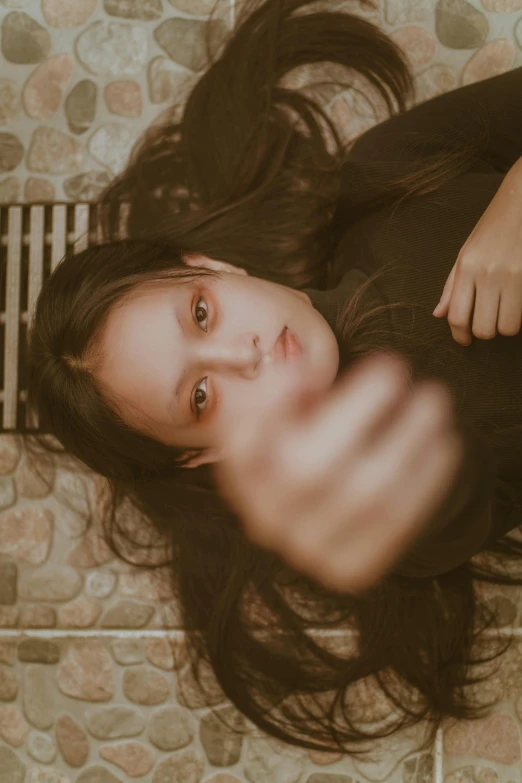 a woman laying on the floor in black sweater and pants