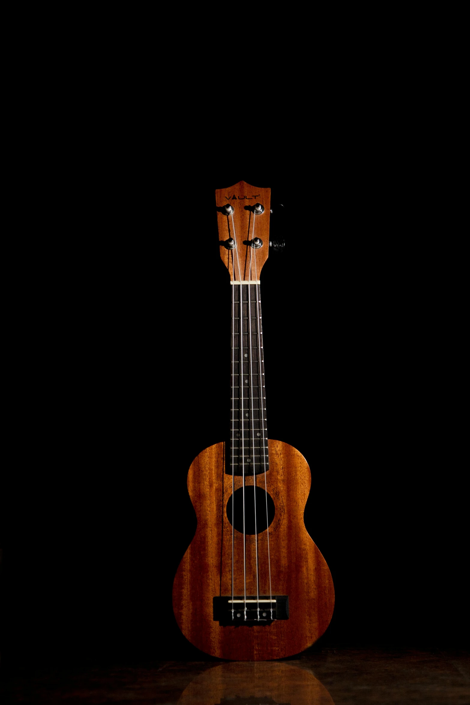 a ukulele on black background with dark space