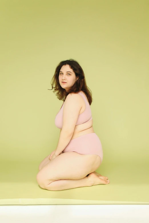 this is a woman kneeling in a pink lingerie