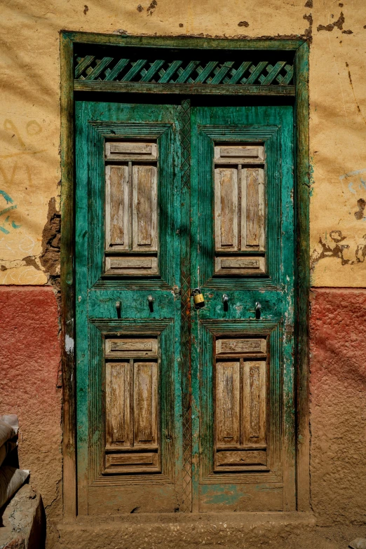 the green door is decorated with an iron rod