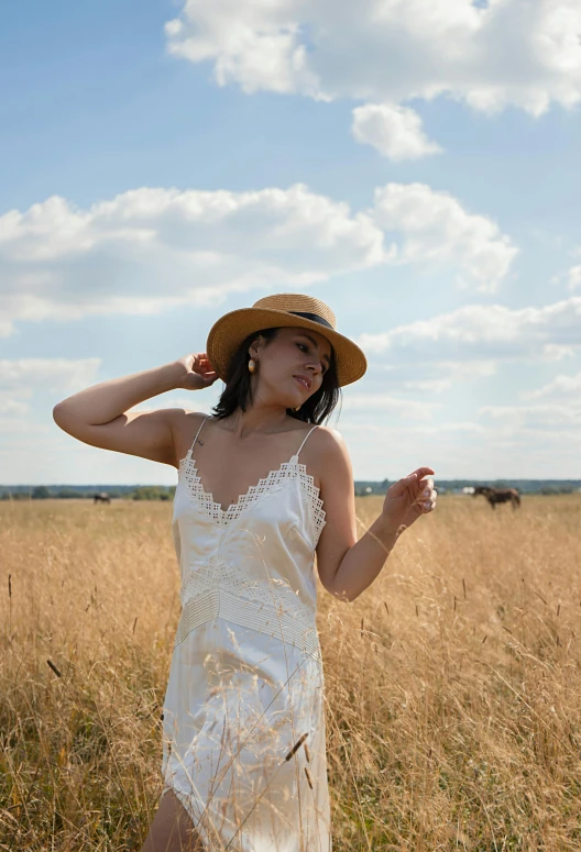 woman in white dress standing in tall grass