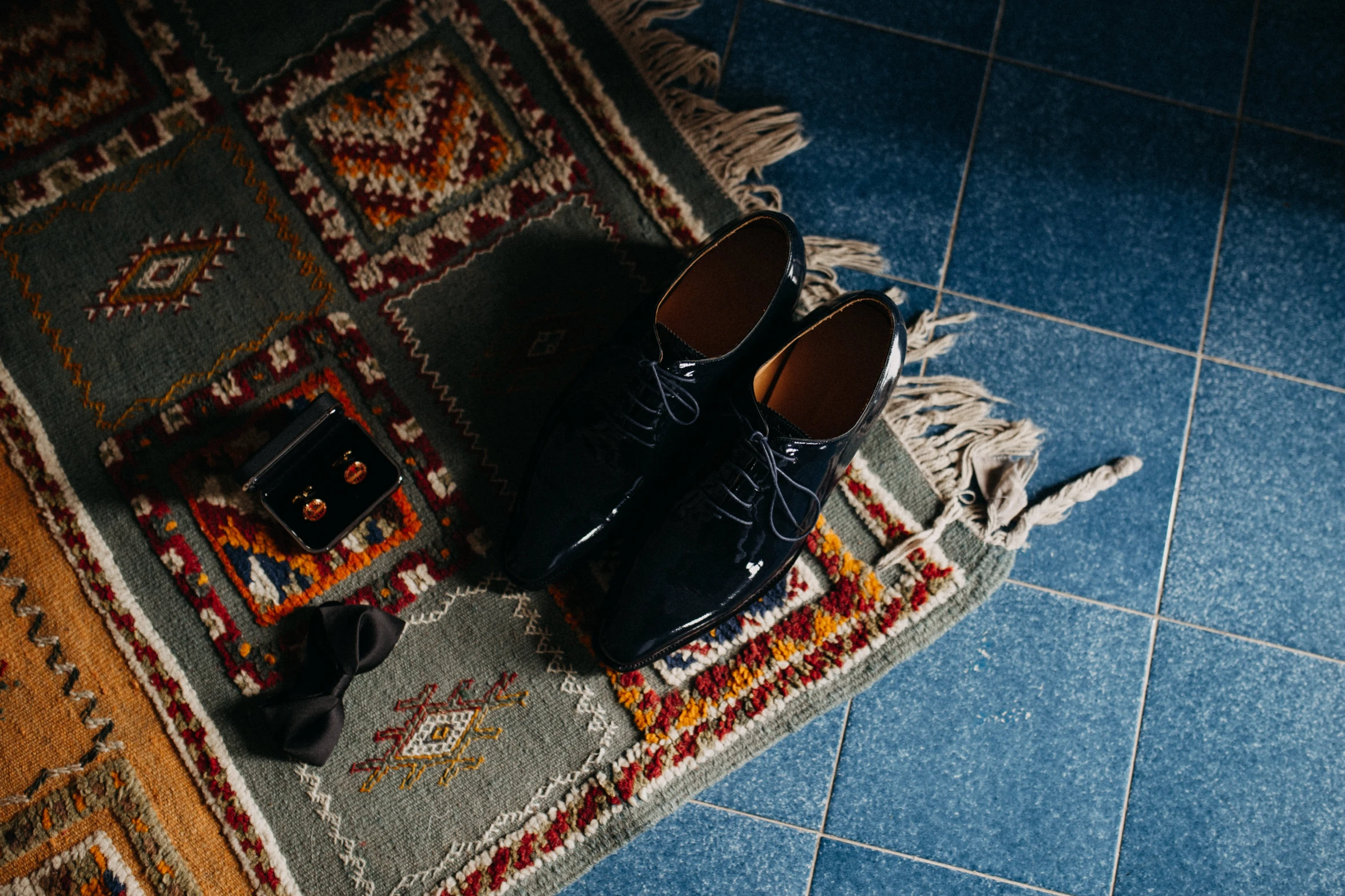 a black shoes and a blue rug on the ground