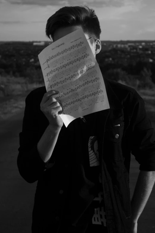 a person holding up a piece of paper over their face