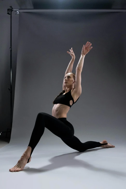 a woman doing a yoga pose against a backdrop