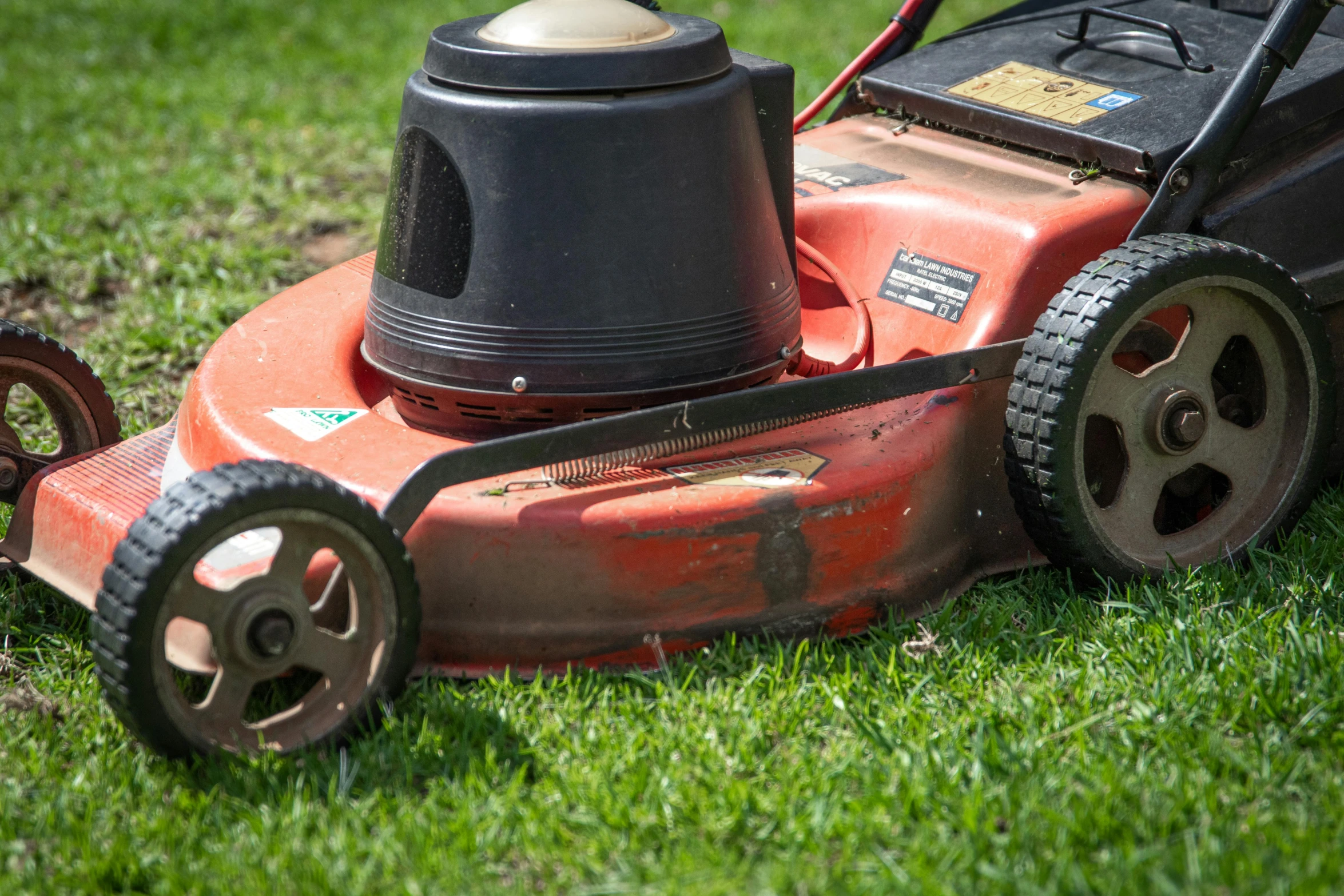 a mower is sitting on the grass outside in the sun