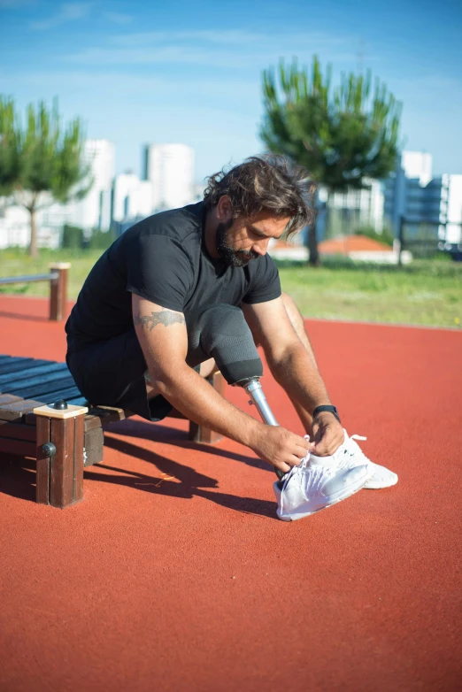 a man is tying up some sneakers with his foot