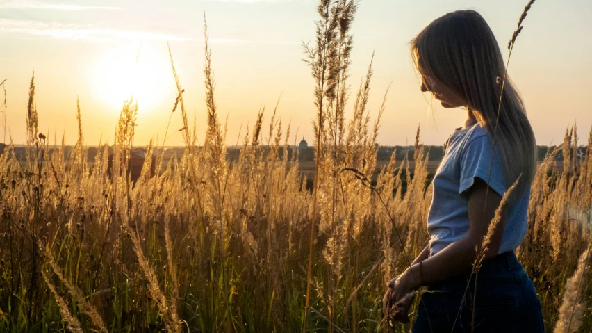 girl in a field standing looking at the sky