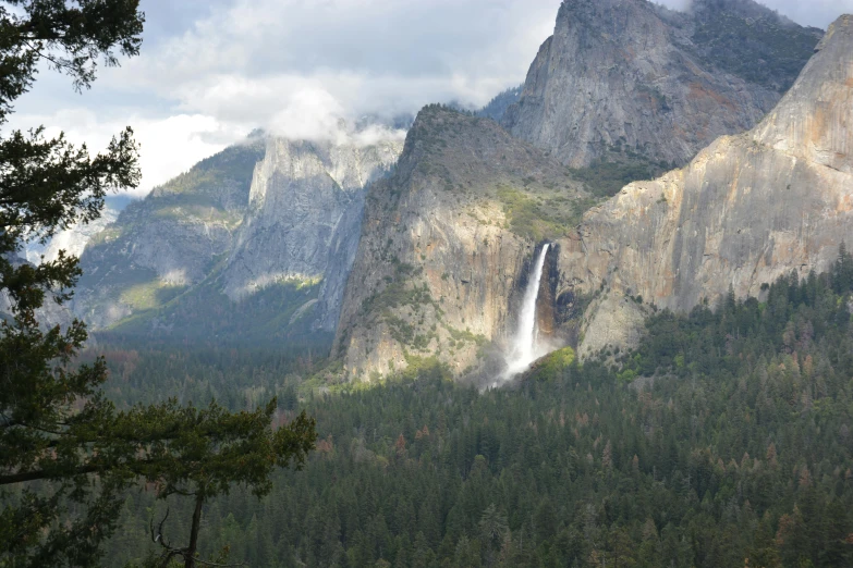 there are mountains that have some trees and a waterfall