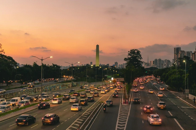 an interstate filled with cars during sunset on a city street