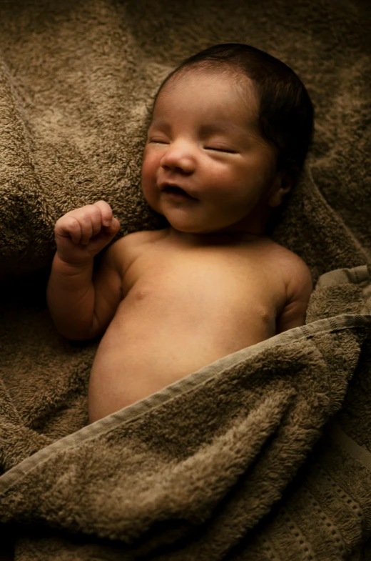 a baby is sleeping on the couch covered by blankets