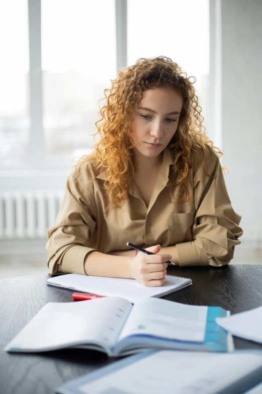 a woman sitting at a table with a book