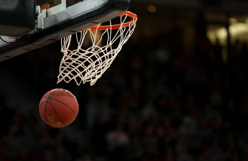 an airbrushed basketball is dangling from a hoop