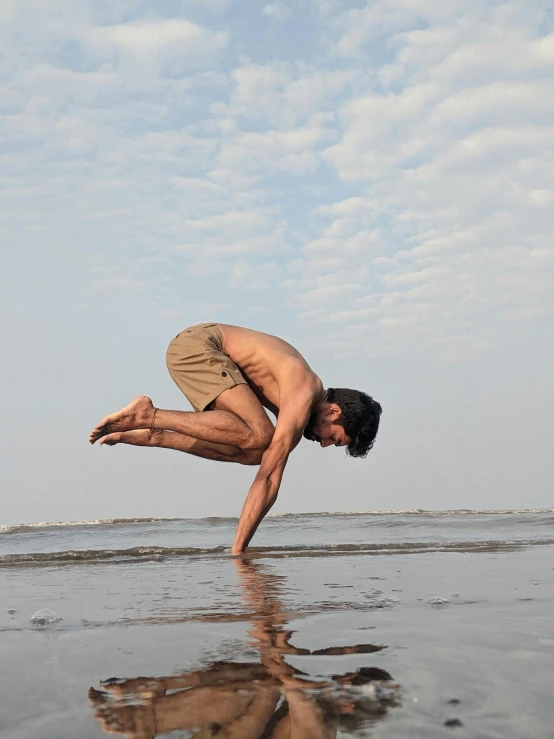 a man is doing a handstand on the beach