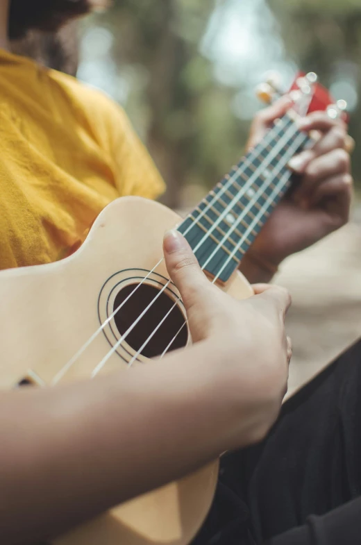 someone playing the ukulele with their hand