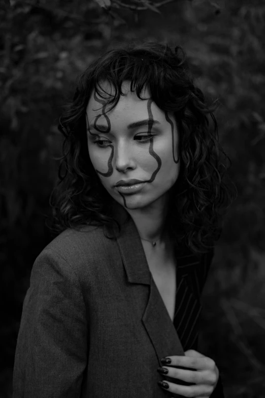 a young woman with painted face looks into the camera