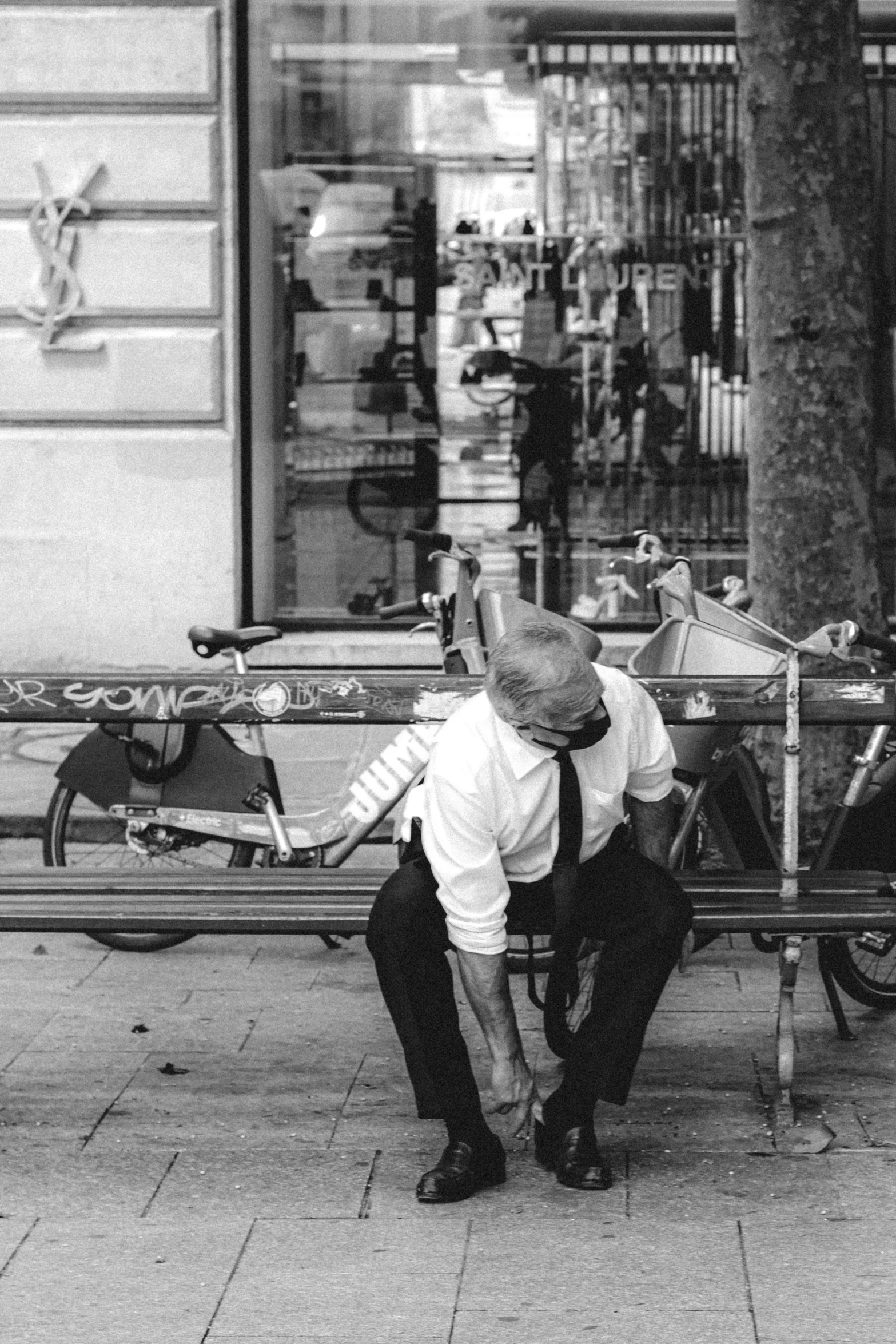 a man kneeling on a bench in front of a bike