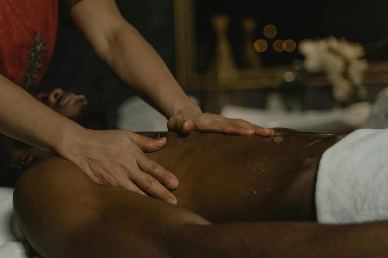 a close up of a person laying on the ground with one hand on the back of another