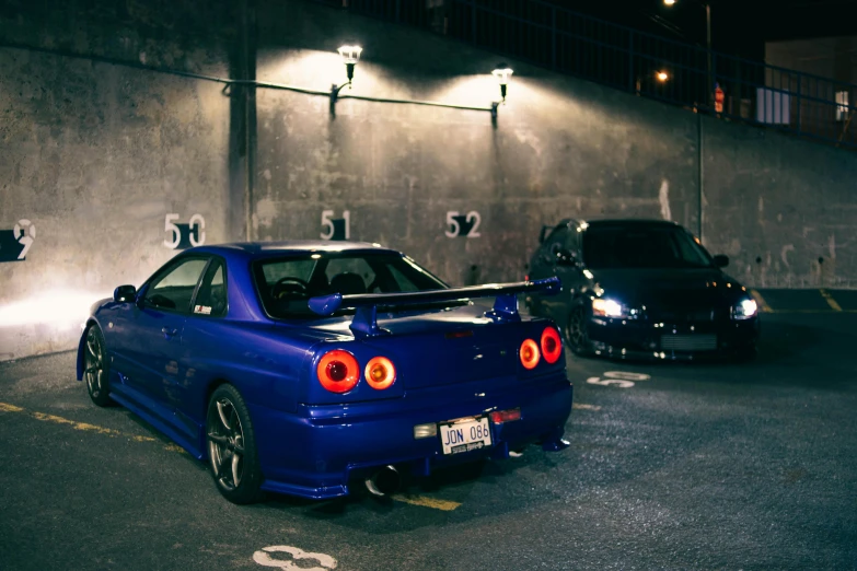 two cars parked in a parking space at night