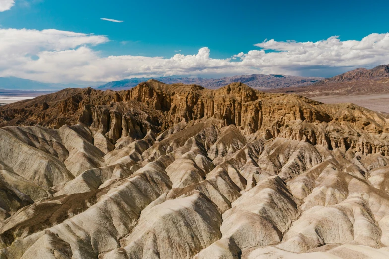 desert land with rocks that resemble mountains with clouds