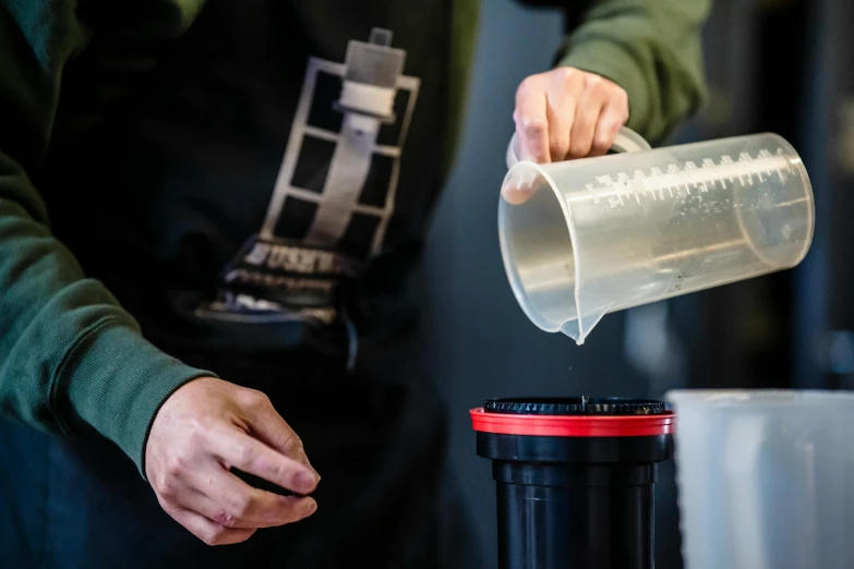 a person pouring some juice into a bottle