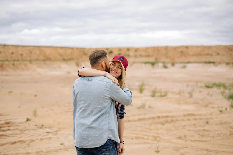 a man and woman standing in the middle of an open field