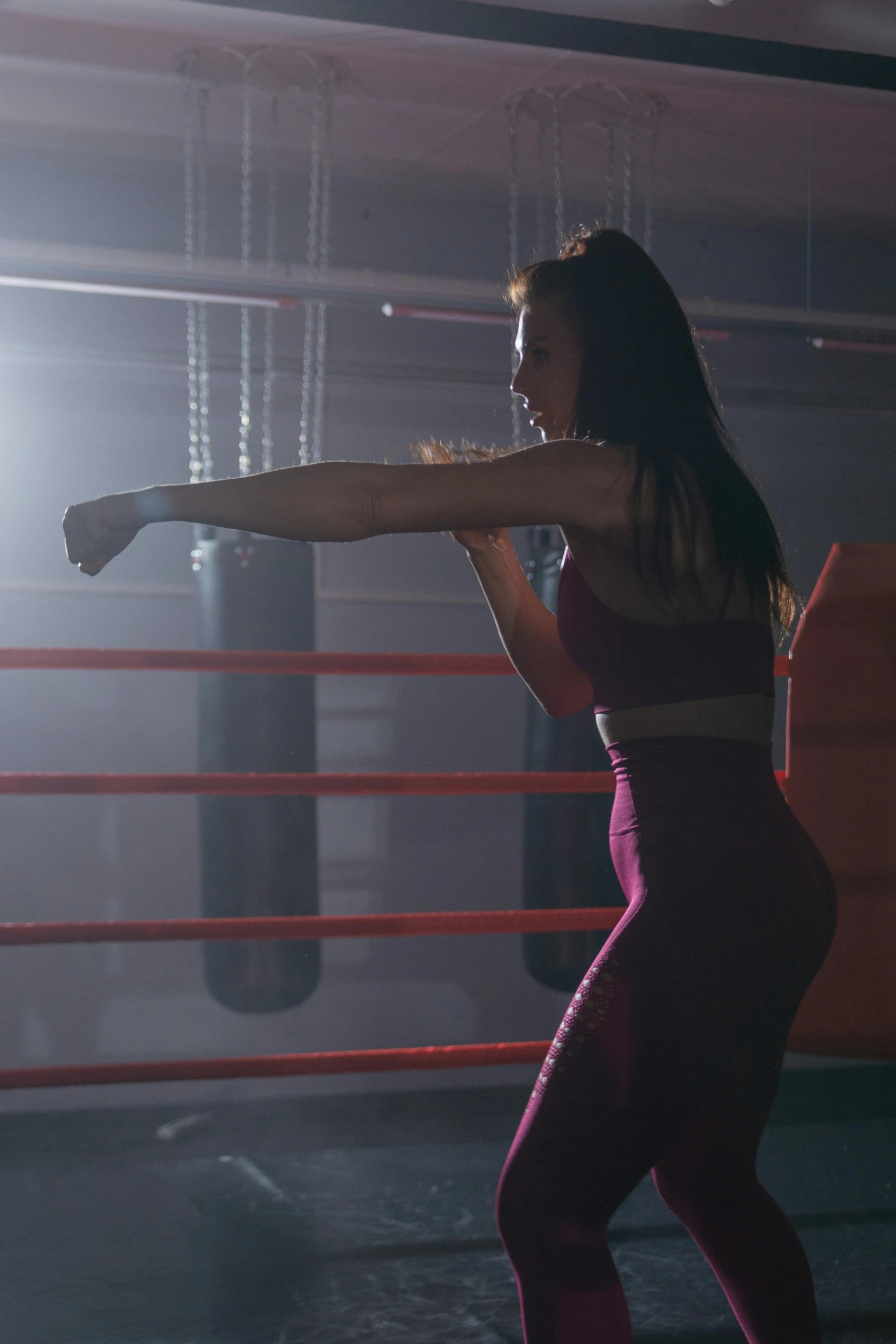 a woman hitting a kick in a boxing ring