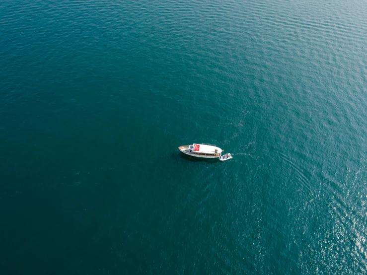 a boat floating across a body of water near the shore