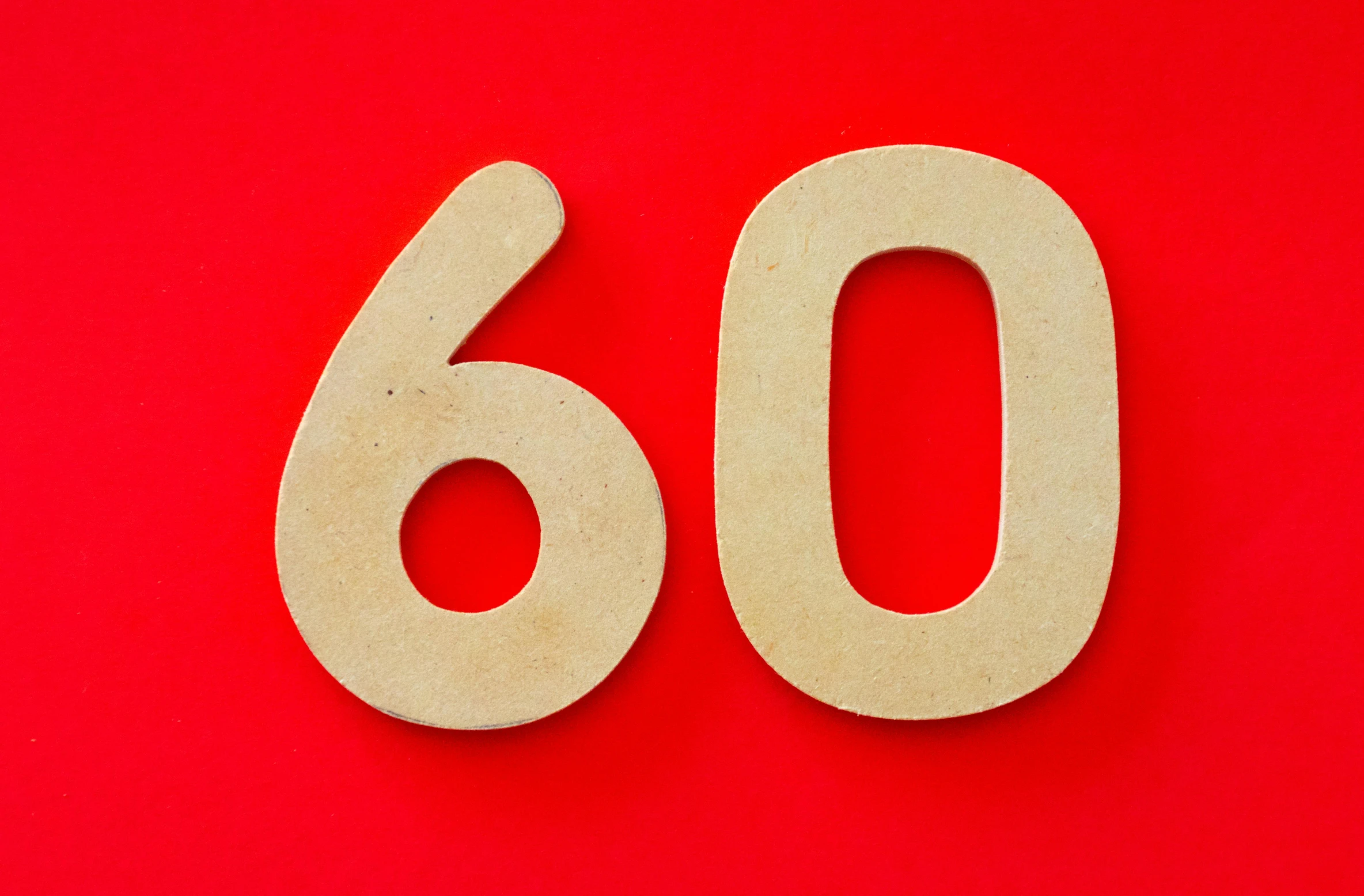 a red table with two wooden numbers that read sixty