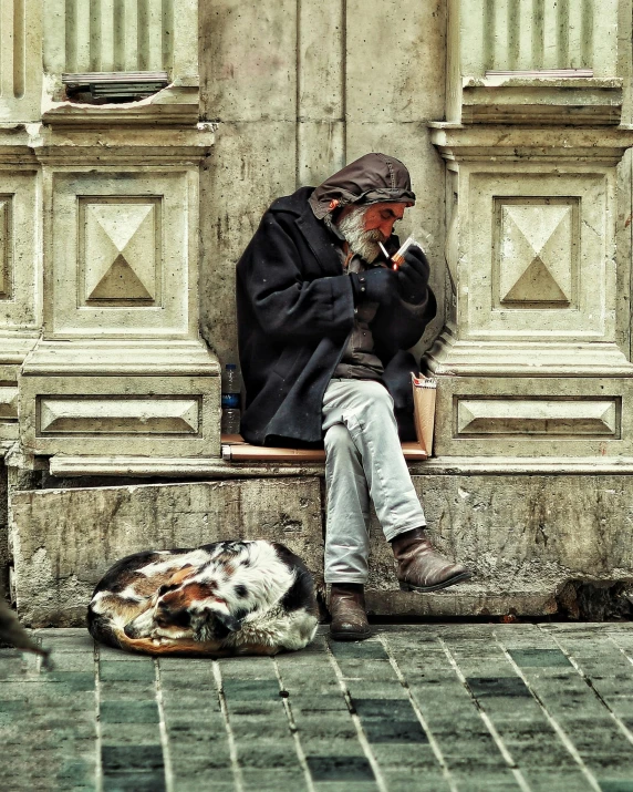a man sits with his dog while smoking